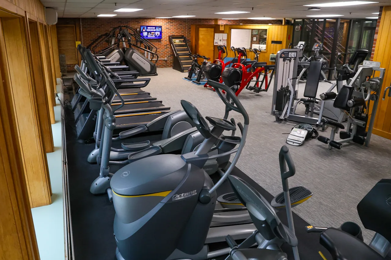 RecFit's cardio floor from one end: ellipticals and stair climbers along the windows, weight machines beyond